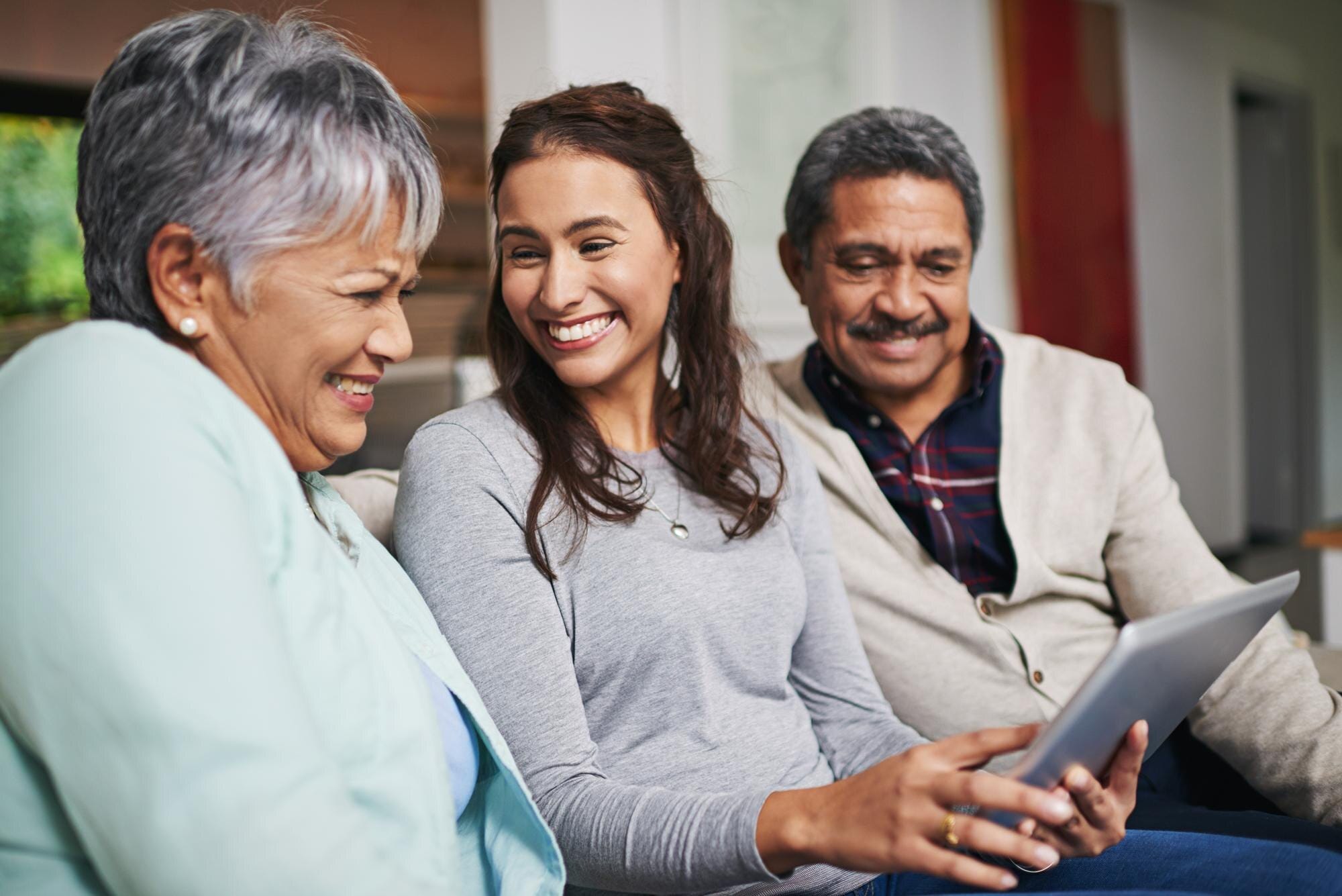 Familia hispana de mediana edad conversando juntos en la sala de estar sobre finanzas del hogar