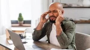 Persona hispana de mediana edad con estrés financiero revisando facturas — estrés financiero y salud